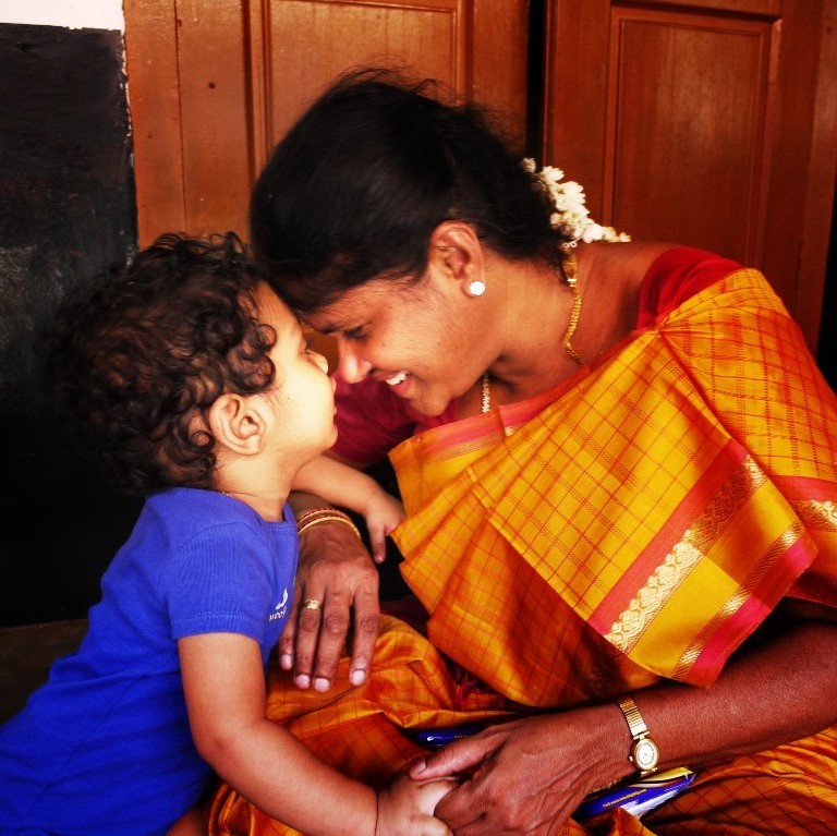 A mother smiles broadly as she nuzzle noses with her toddler son. A mother smiles broadly as she nuzzle noses with her toddler son.