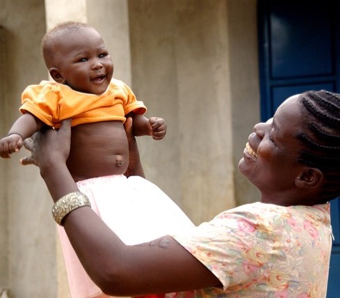 A mother playfully lifts her baby above her head to the bay's delight. A mother playfully lifts her baby above her head to the bay's delight.
