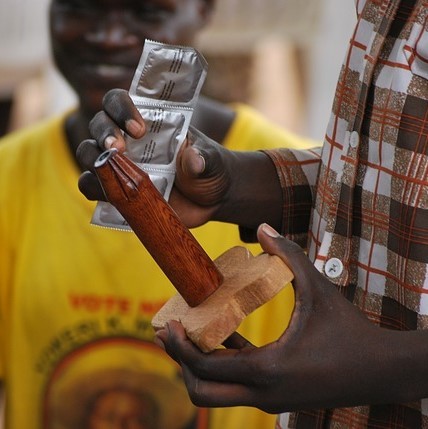 A sex education instructor holds a package of condoms and a wooden model of a penis before giving a demonstration of proper condom use. A sex education instructor holds a package of condoms and a wooden model of a penis before giving a demonstration of proper condom use.