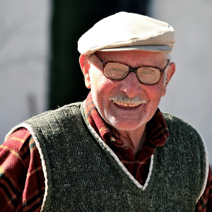 A fit looking older gentleman stands smiling in the sunshine. A fit looking older gentleman stands smiling in the sunshine.