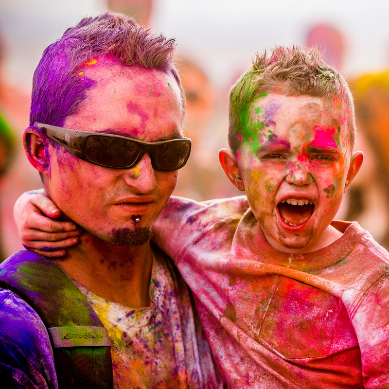 A father and son smile and shout after finishing an exciting race called The Color Run. Both are covered from head to toe in many shades of brightly colored powder. A father and son smile and shout after finishing an exciting race called The Color Run. Both are covered from head to toe in many shades of brightly colored powder.
