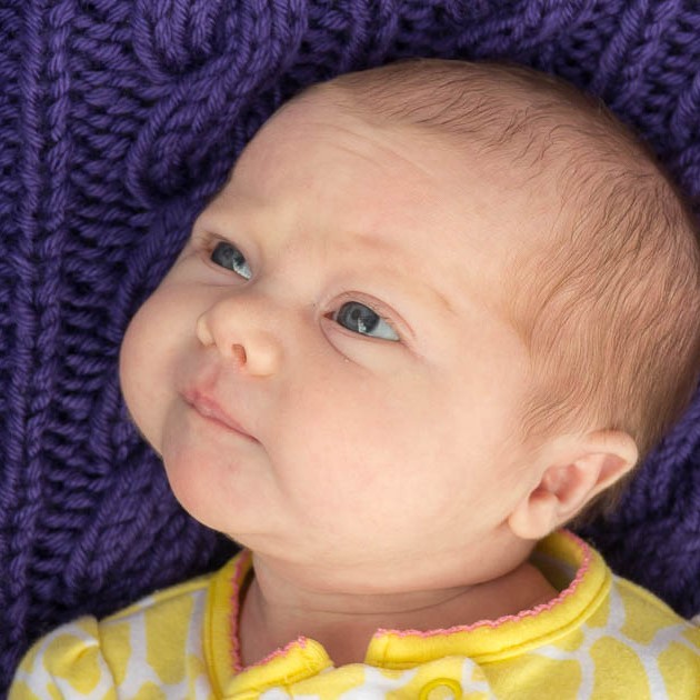 An infant lies on its back with its eyes fixed on a nearby object. An infant lies on its back with its eyes fixed on a nearby object.