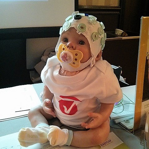An infant wears an EEG cap. An infant wears an EEG cap.