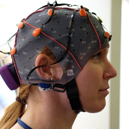 A woman wearing an EEG cap. A woman wearing an EEG cap.