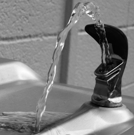 Clear water flows from a public drinking fountain. Clear water flows from a public drinking fountain.