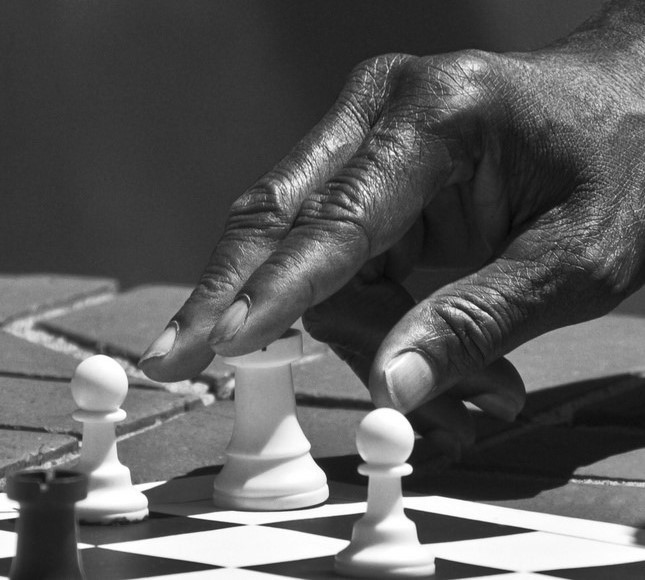 A chess player with his hand on a rook. A chess player with his hand on a rook.