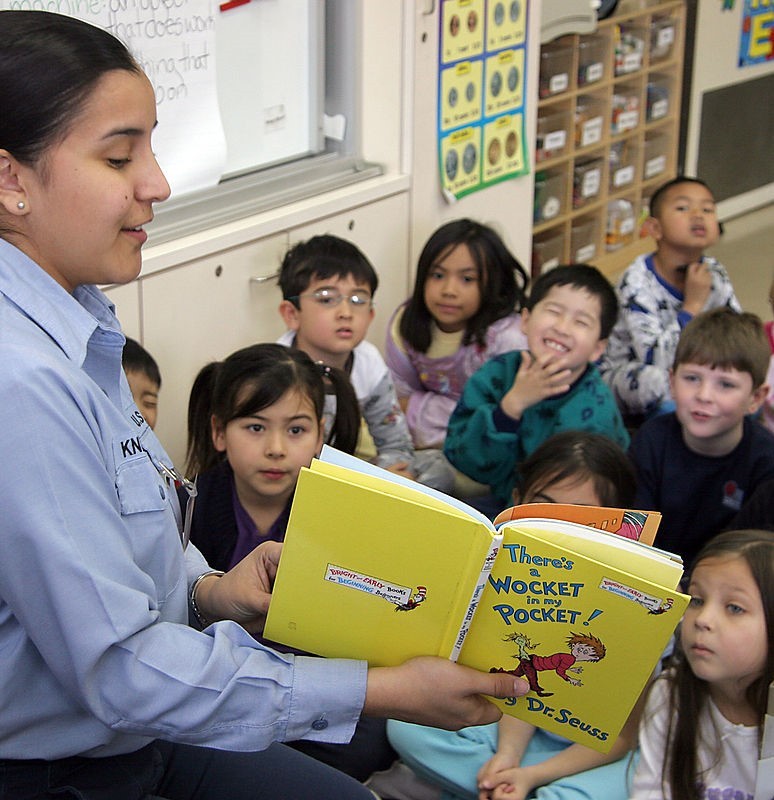 A teacher reads a story to a group of grade school students. A teacher reads a story to a group of grade school students.