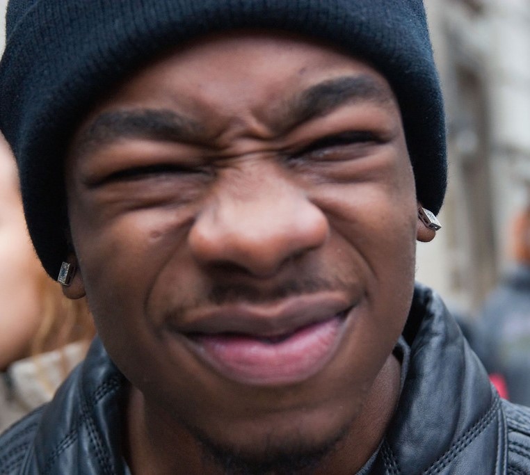 A man displays a common expression of disgust - wrinkled nose, lowered brows, narrowed eyes, raised cheeks, and curled upper lip. A man displays a common expression of disgust - wrinkled nose, lowered brows, narrowed eyes, raised cheeks, and curled upper lip.