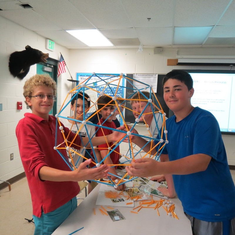 A group of boys at science camp show off the geodesic sphere they've built together. A group of boys at science camp show off the geodesic sphere they've built together.