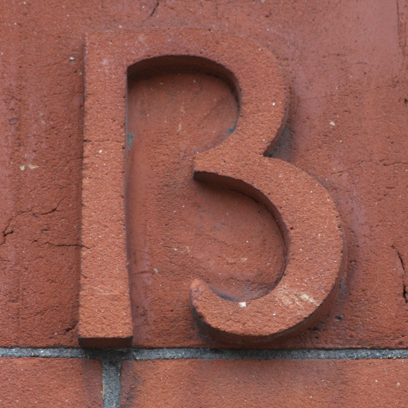 Close up image of the marking on the side of a building. It isn't clear if the marking is the number 13 or the letter B. Close up image of the marking on the side of a building. It isn't clear if the marking is the number 13 or the letter B.