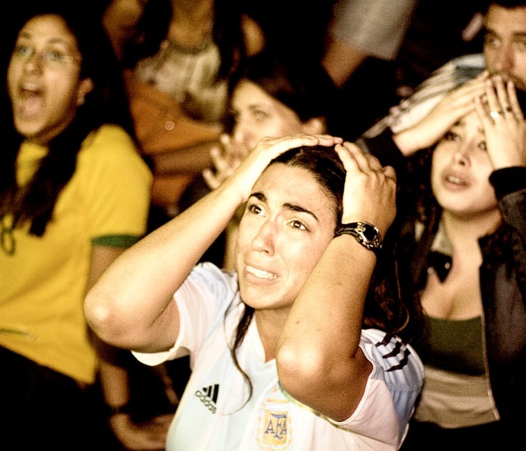 An Argentine soccer fan wearing a national team jersey reacts in horror as she watches a match on television. An Argentine soccer fan wearing a national team jersey reacts in horror as she watches a match on television.