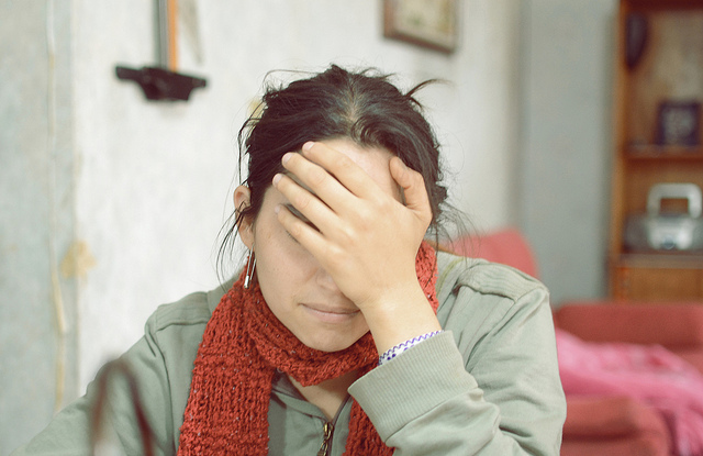 A woman covers her face in embarrassment. A woman covers her face in embarrassment.