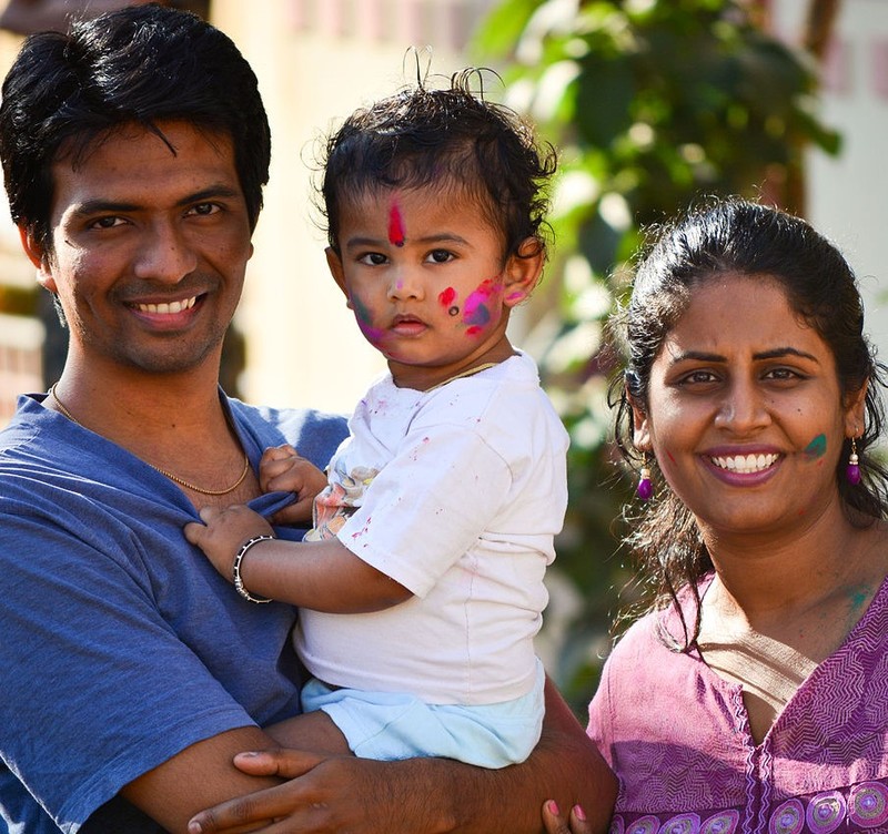 An Indian mother and father pose for a photo with their son who has had his face painted during a religious festival. An Indian mother and father pose for a photo with their son who has had his face painted during a religious festival.