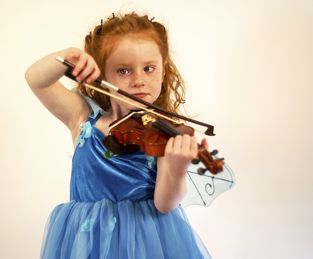 A young girl practicing the violin. A young girl practicing the violin.