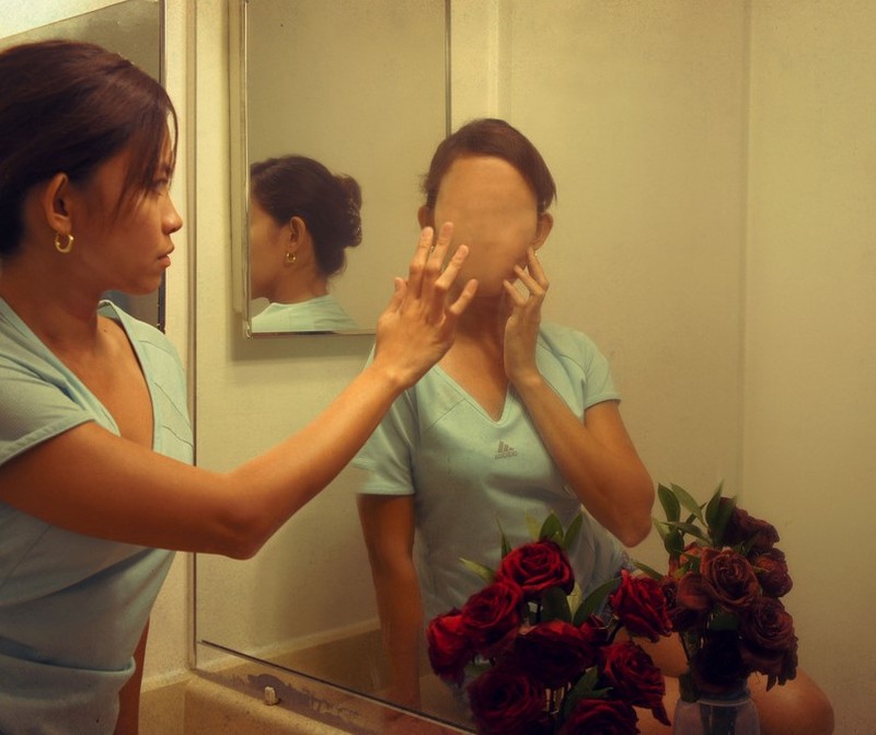 A woman looks into the mirror and sees a faceless reflection. A woman looks into the mirror and sees a faceless reflection.