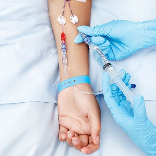 Close up of a patient arm fitted with an IV drip. Close up of a patient arm fitted with an IV drip.
