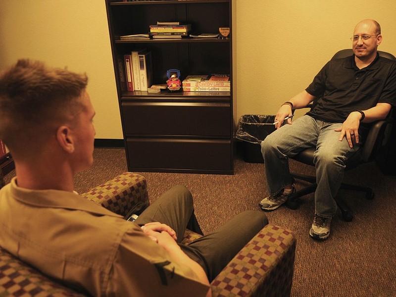 A therapist and patient sit facing one another during a session. A therapist and patient sit facing one another during a session.
