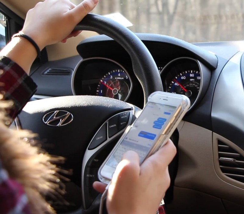 A woman texting as she drives. A woman texting as she drives.