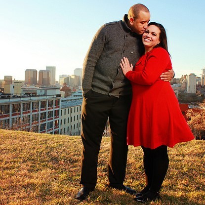A young, attractive couple pose for a photo in front of a city skyline. A young, attractive couple pose for a photo in front of a city skyline.