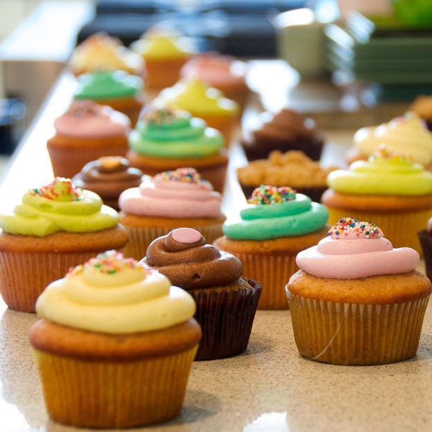 cupcakes and cookies arranged on a table for sale. cupcakes and cookies arranged on a table for sale.