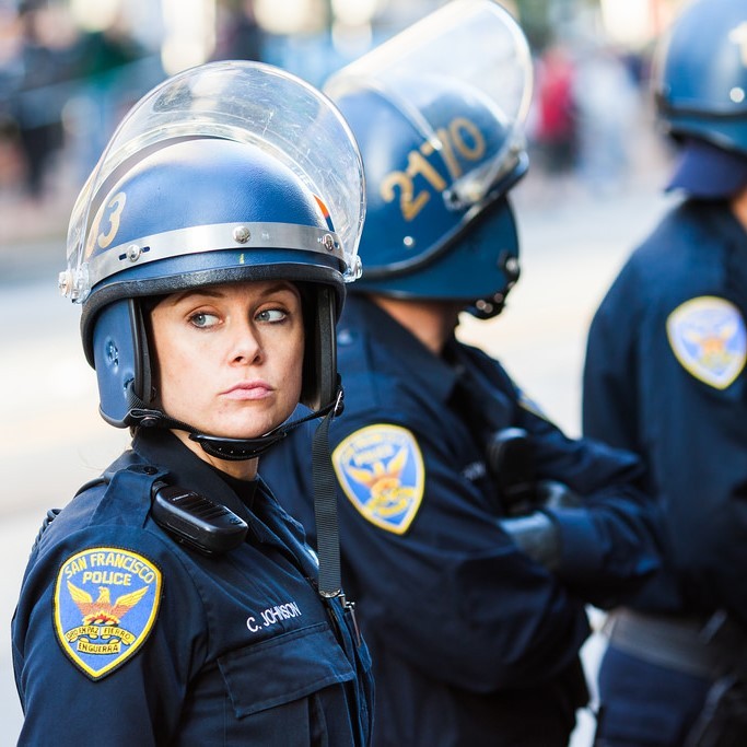 A group of police officers hearing helmets and face shields. A group of police officers hearing helmets and face shields.