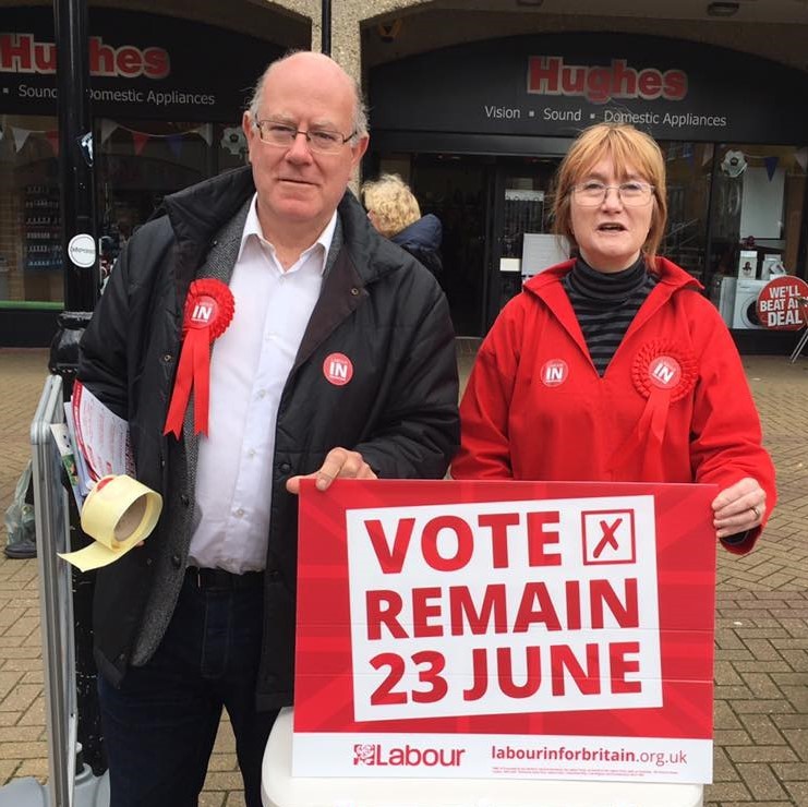 A man and woman stand behind a campaign sign urging voters to "Vote Remain 23 June". A man and woman stand behind a campaign sign urging voters to "Vote Remain 23 June".