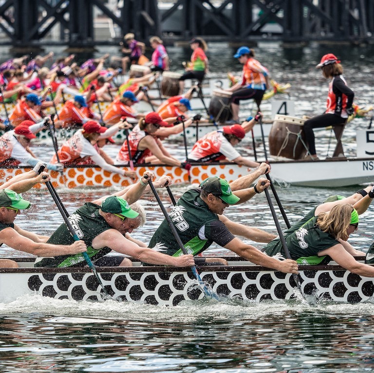 Boats filled with teams of rowers compete in a race. Boats filled with teams of rowers compete in a race.