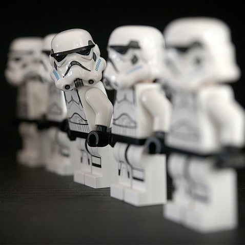 A line of identically dressed stormtroopers from the Star Wars films. One stormtrooper is stepping out of formation and looking at the others in the group. A line of identically dressed stormtroopers from the Star Wars films. One stormtrooper is stepping out of formation and looking at the others in the group.