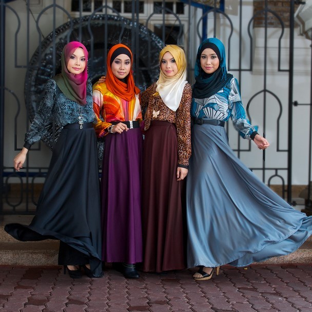A group of Malaysian fashion models pose in colorful headscarves, long-sleeved blouses, and floor-length dresses. A group of Malaysian fashion models pose in colorful headscarves, long-sleeved blouses, and floor-length dresses.