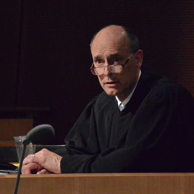 A judge dressed in a traditional black robe. A judge dressed in a traditional black robe.