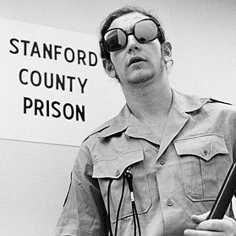 Photo of a participant guard from the Stanford Prison Experiment wearing sunglasses and holding a truncheon. Photo of a participant guard from the Stanford Prison Experiment wearing sunglasses and holding a truncheon.