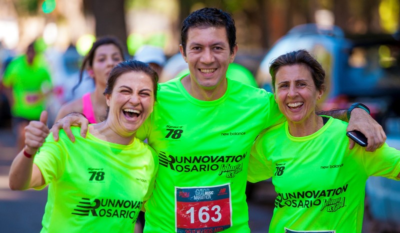 Teammates in matching shirts celebrate together at the end of a marathon. Teammates in matching shirts celebrate together at the end of a marathon.