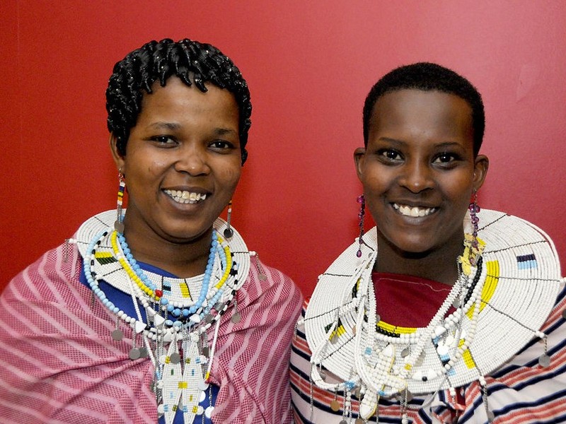 Two teen aged Maasai girls pose together in traditional clothing. Two teen aged Maasai girls pose together in traditional clothing.