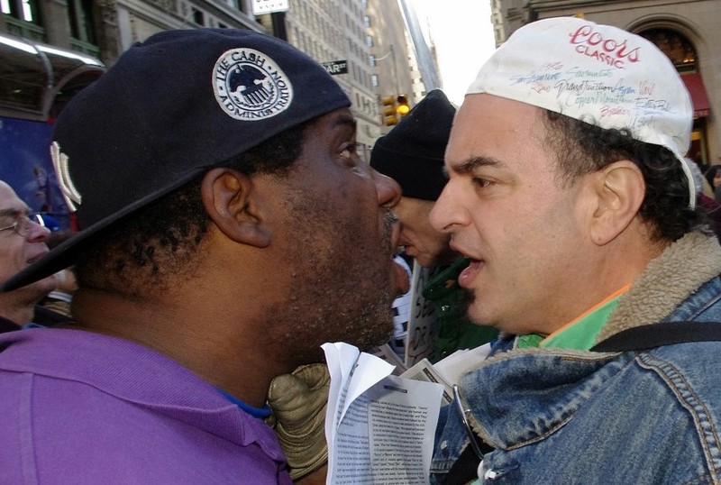 Two men stand almost nose-to-nose as they argue in the street. Two men stand almost nose-to-nose as they argue in the street.