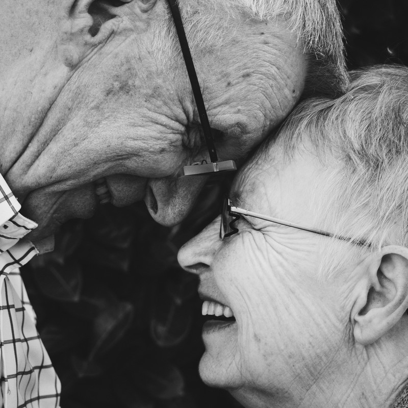 An elderly couple embrace and look into each other's eyes. An elderly couple embrace and look into each other's eyes.