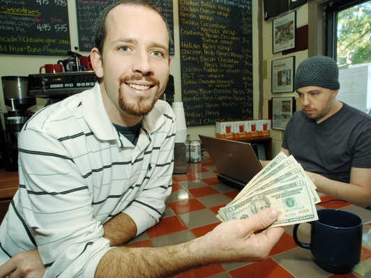 Coffee shop owner Josh cooks shows 100 dollars that were donated by a generous customer to buy drinks for strangers. Coffee shop owner Josh cooks shows 100 dollars that were donated by a generous customer to buy drinks for strangers.