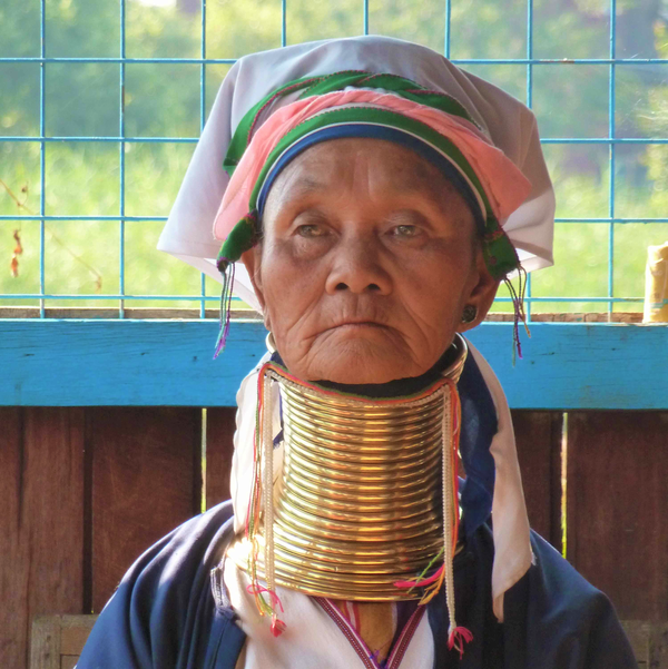 An older Kayan woman (Myanmar) wears traditional clothing and brass rings around her neck. The rings produce the impression that the neck is longer than normal. An older Kayan woman (Myanmar) wears traditional clothing and brass rings around her neck. The rings produce the impression that the neck is longer than normal.